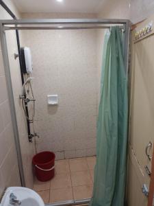 MukahHighway Inn的带淋浴、卫生间和红色桶的浴室