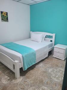 菲兰迪亚Vivienda Turistica Cattleya的一间卧室配有一张蓝色墙壁的床