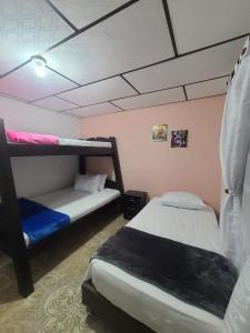菲兰迪亚Vivienda Turistica Cattleya的一间卧室设有两张双层床和粉红色的墙壁。