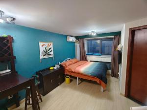 天津宇璟轩精品公寓的一间卧室配有一张床、一张书桌和一个窗户。