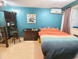 天津宇璟轩精品公寓的一间卧室设有一张床和蓝色的墙壁