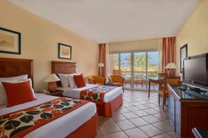 考拉亚湾Jaz Grand Marsa的酒店客房设有两张床和一台平面电视。