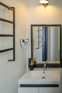 萨莱L'Aparté的浴室配有带镜子的盥洗盆和吹风机