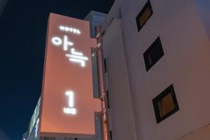 清州市Aank Hotel Cheongju 1的夜间建筑物一侧的标志