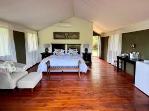 KirkwoodNdlovu Addo River Lodge的一间卧室配有一张床和一张沙发