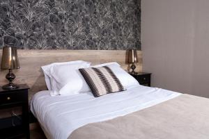 萨莱L'Aparté的卧室内的一张带白色床单和枕头的床