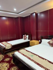 Tây Ninh那克酒店的紫色墙壁客房的两张床