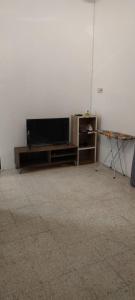 巴力文打NTC Homestay at Parit Buntar的客厅配有平面电视和桌子。