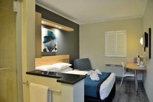 约翰内斯堡Road Lodge Randburg的配有一张床和一张书桌的酒店客房