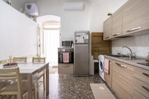 滨海波利尼亚诺Chiarina rooms的厨房配有不锈钢冰箱和桌子