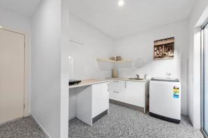 斯卡伯勒Scarborough Beach Break Holidays - Unit 5的厨房配有白色橱柜和冰箱。