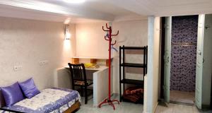 马拉喀什Shared apartment-Appartement en colocation tout confort centre ville的客房设有一张床、一张桌子和一把椅子。