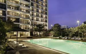 曼谷邦纳自豪公寓式酒店的大楼前的游泳池