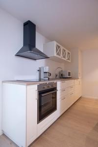 桑内斯Koselig studioleilighet i Sandnes sentrum的厨房配有白色橱柜和炉灶。