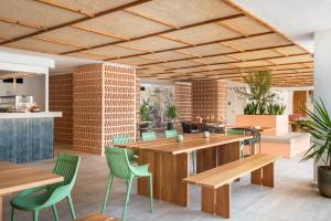 普拉亚登博萨Hotel Vibra Algarb的餐厅设有木桌和绿色椅子