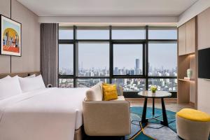 上海上海桃浦雅辰悦居酒店的酒店的客房 - 带一张床、椅子和窗户