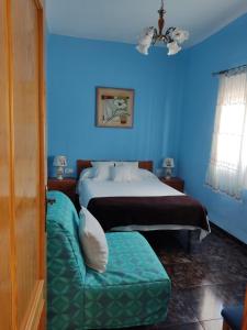 马萨龙港Playa Rihuete 2的蓝色的卧室配有床和沙发