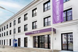 雷根斯堡Premier Inn Regensburg City Centre的白色的建筑,上面有紫色的标志