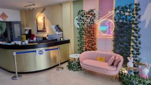 古晋国王中心一点酒店的一间位于商店的带粉红色椅子的等候室