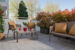 切塞纳蒂科Nido Suite & Apartments的庭院配有桌椅和盆栽植物