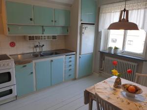 斯塔德Egen ovanvåning i charmig villa nära havet的厨房配有蓝色橱柜和鲜花桌