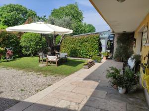 米拉诺COUNTRY HOUSE CASAMIRIAM的庭院配有遮阳伞和桌椅。