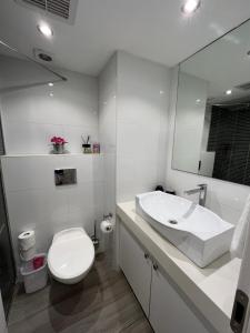荷兹利亚Last Minute Herzliya的白色的浴室设有卫生间和水槽。