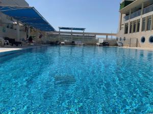 荷兹利亚Last Minute Herzliya的大楼前的大型蓝色游泳池