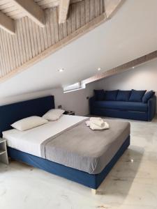 阿吉亚特拉萨阿尔米拉酒店的一间卧室配有一张床和一张蓝色的沙发