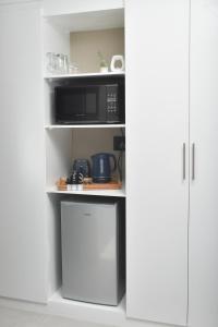 比勒陀利亚Falcons Rest的厨房配有微波炉和冰箱。