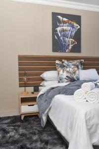 比勒陀利亚Falcons Rest的一间卧室配有一张大床和木制床头板