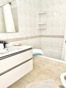 巴耶格兰雷伊Molino Azul 3A, Wohnung mit Meerblick的一间带水槽、浴缸和卫生间的浴室