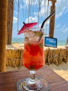卡尔皮蒂耶Windy Waves Kite Beach & Nature Resort的坐在桌子上,在玻璃杯里喝一杯