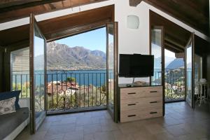 贝拉吉奥ALBA e TRAMONTO Appartamenti vista lago的卧室设有带电视的大阳台