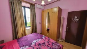唐吉莫利尼Apartment Capt Seferovic 2的一间卧室设有粉红色的墙壁和一张紫色床单。