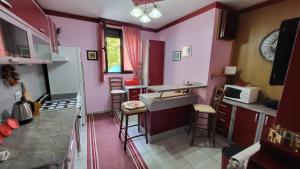 唐吉莫利尼Apartment Capt Seferovic 2的厨房设有粉红色的墙壁和酒吧凳子
