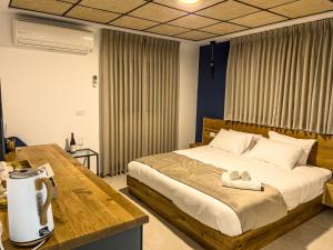 Mas'adaGoland Hotel的一间卧室配有一张床和一张桌子,上面有毛巾