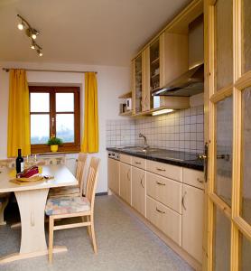 丘萨Moarhof Gufidaun的厨房配有桌子、黄色窗帘和桌椅