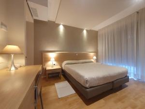 利尼亚诺萨比亚多罗Hotel Eurovil Garni的一间卧室配有一张床和一张带两盏灯的书桌。