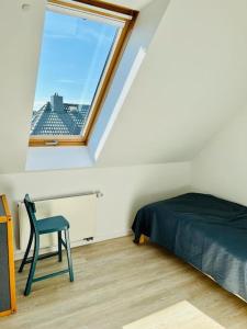 FahrdorfLichtdurchflutete Ferienwohnung mit direktem Schleiblick的卧室配有床、椅子和窗户。