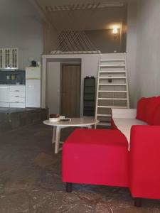 奥马斯帕纳吉亚斯Loft house 2的客厅配有桌子和红色沙发