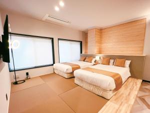 GotsuFELIZ ARIFUKU ONSEN的一间卧室设有两张床和大窗户