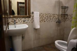 拉合尔GO Luxury Grand Hotel的一间带水槽、卫生间和镜子的浴室