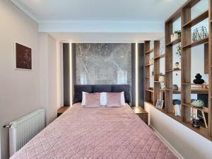 克卢日-纳波卡Panorama Deluxe Aparthotel的一间卧室配有一张带粉红色床罩的床