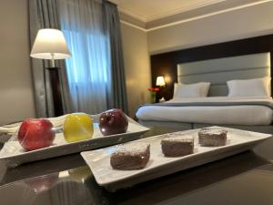 贝鲁特Ramada by Wyndham Downtown Beirut的在酒店房间桌子上放两个水果盘
