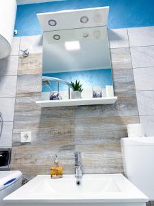 里耶卡Luxury Apartman ASIA Rijeka的一间带水槽和镜子的浴室