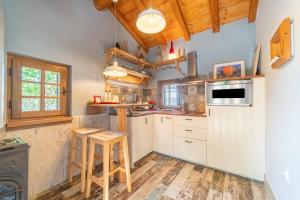 斯达林Mini Country House的厨房铺有木地板,配有白色橱柜。