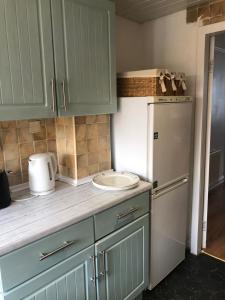 Ince-in-MakerfieldThe White House - Cheerful 3 Bedroom home in Wigan - Ince - sleeps 7 - parking - Work space - Great motorway links的厨房配有绿色橱柜和白色冰箱