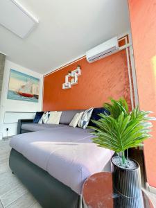 里耶卡Luxury Apartman ASIA Rijeka的一间卧室配有一张床和一张植物桌子