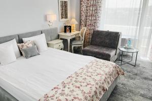 奥拉迪亚大陆论坛奥拉迪亚酒店的一间卧室配有一张大床和一把椅子